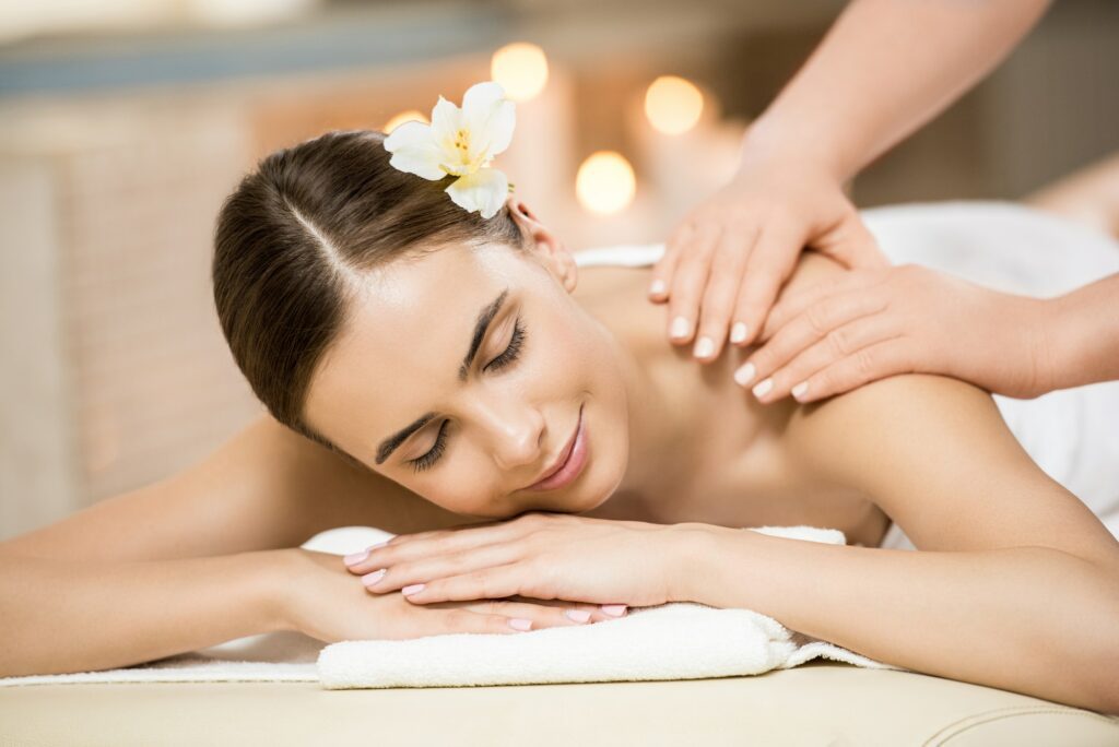 Beautiful woman relaxing and having massage in massage salon
