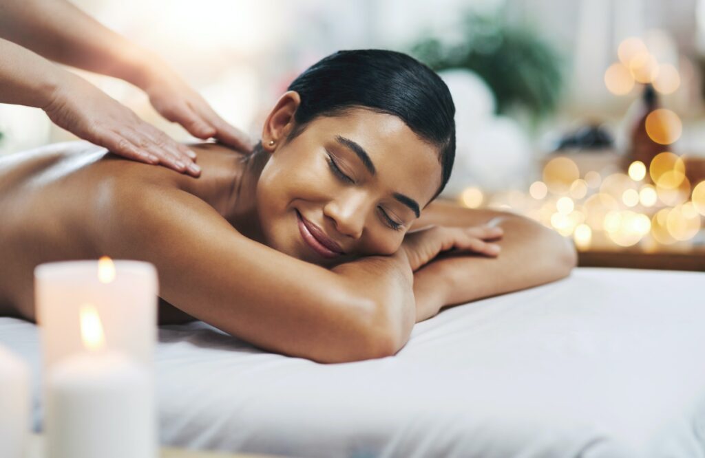 Shot of a relaxed an cheerful young woman getting a massage indoors at a spa